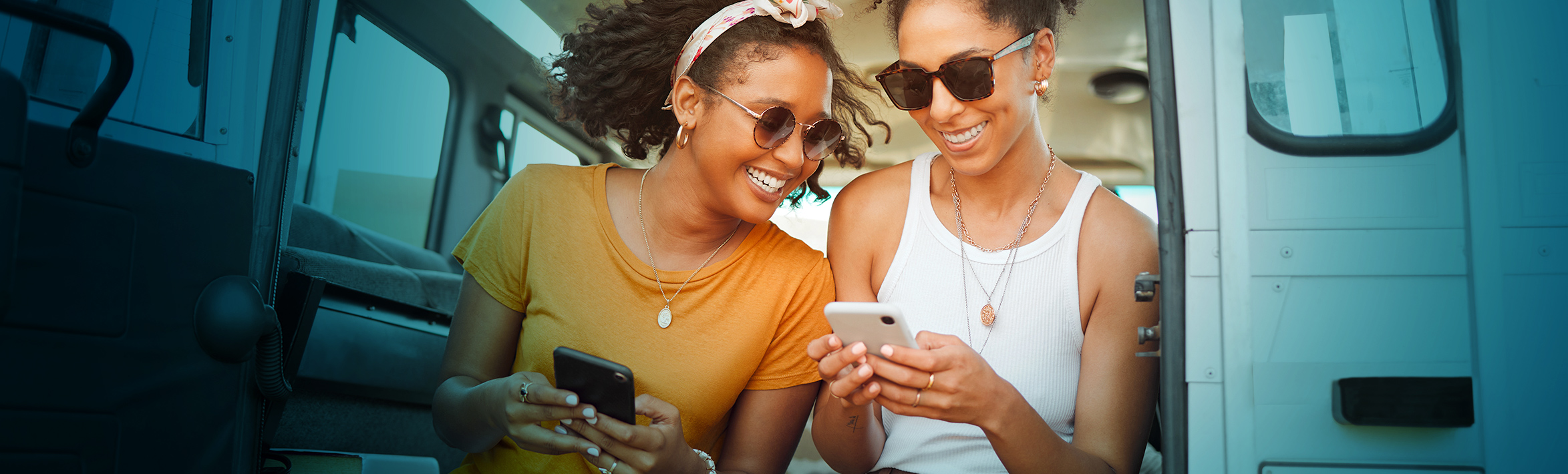 Two adults looking at their phones, smiling.