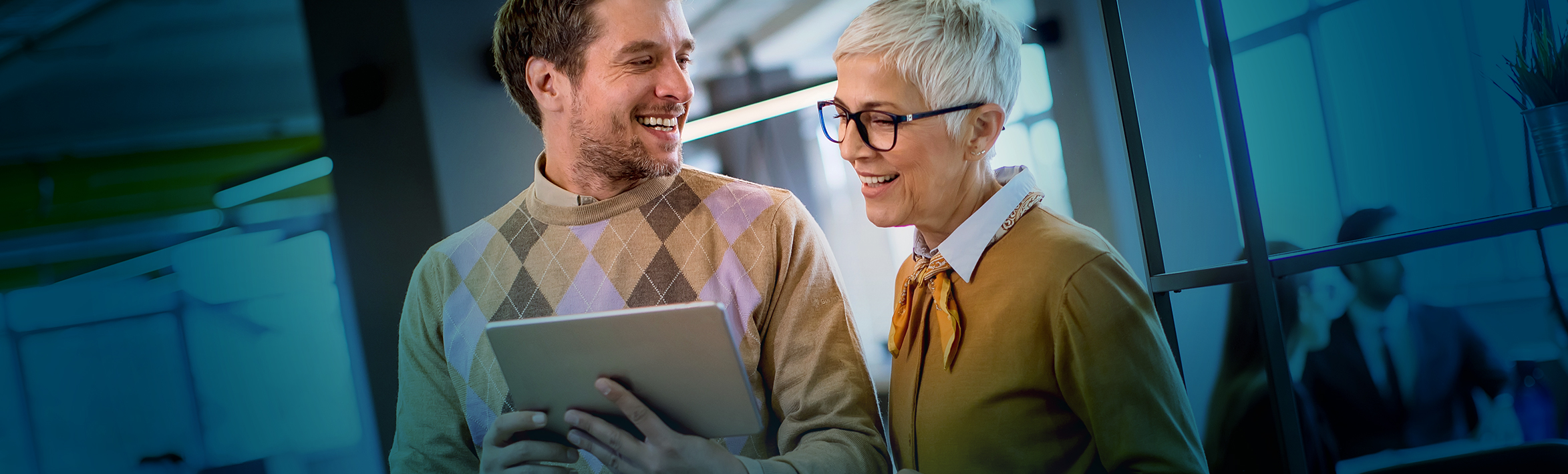 Two adults looking at a tablet.