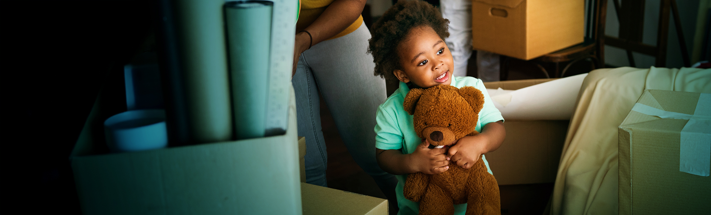 Toddler holding a teddy bear and smiling